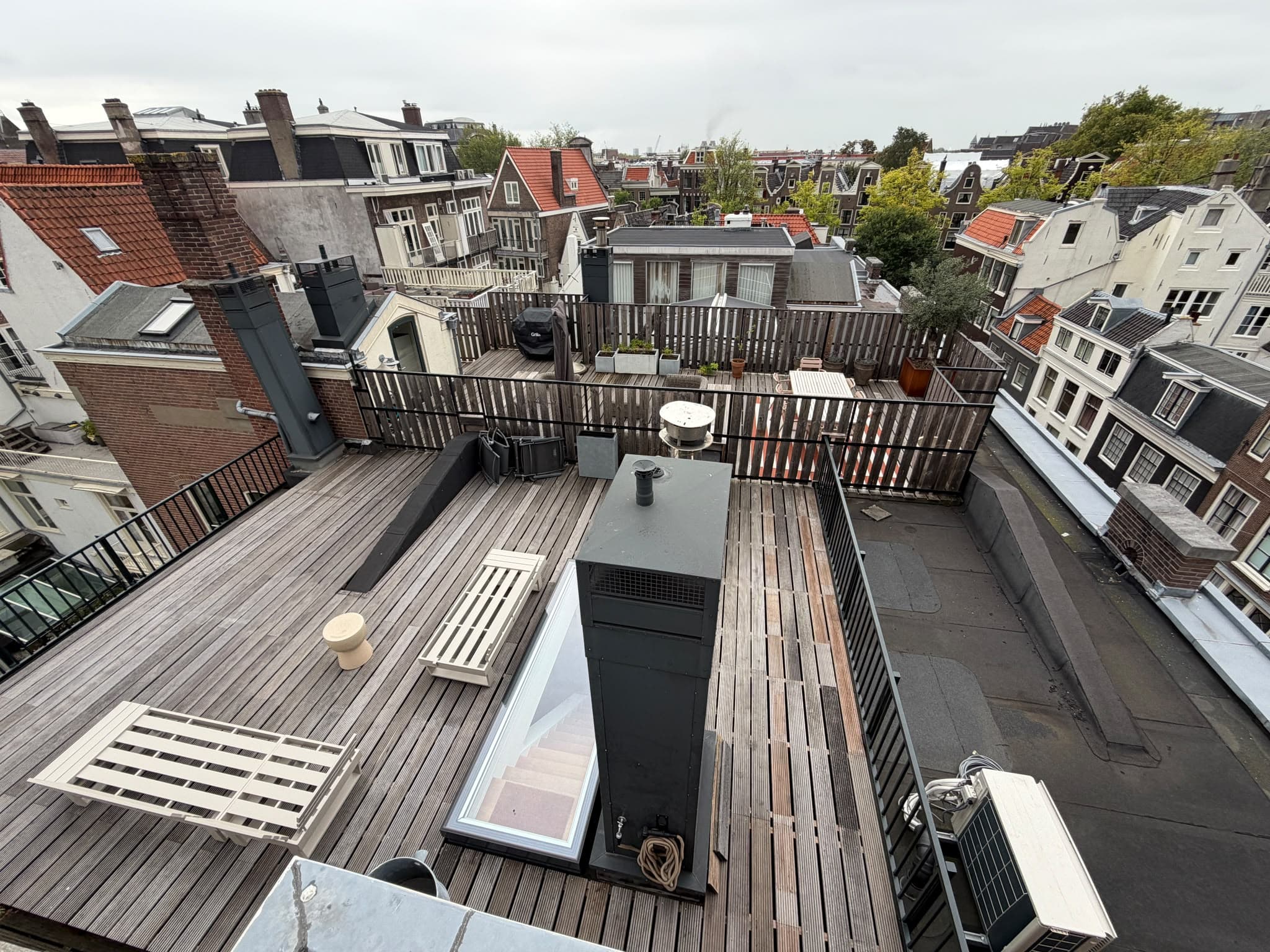 Aangelegd dakterras met vlonder, zitje en beplanting op een Amsterdams grachtenpand